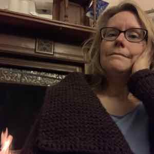 Plum wool CardiZen sweater by the fireplace knit by Alanna Nelson